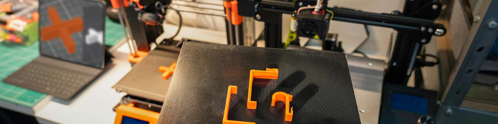 3D-printer ja valmis detailid tööpinnal – prototüüpide loomine ja testimine praktilises keskkonnas